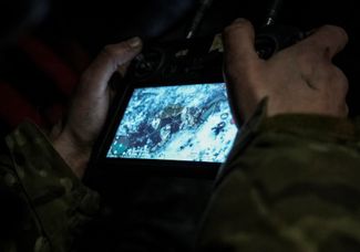 Украинский военнослужащий в реальном времени рассматривает кадр с тела российского солдата, убитого FPV-дроном-камикадзе на передовой