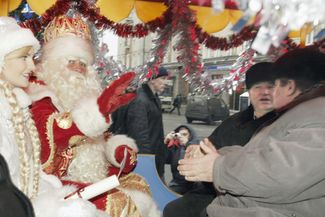 Мэр Москвы Юрий Лужков встречает официального Деда Мороза (и Снегурочку) на Тверской площади в Москве. 27 декабря 2003 года