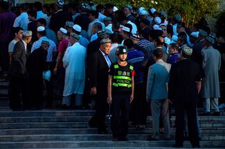 A Chinese police officer outside the central mosque of Kashgar just before the morning prayer, June 26, 2017