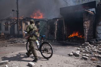 Военнослужащий самопровозглашенной ЛНР на рынке города Попасная Луганской области. Рынок загорелся в результате обстрелов. Сейчас город под контролем ЛНР