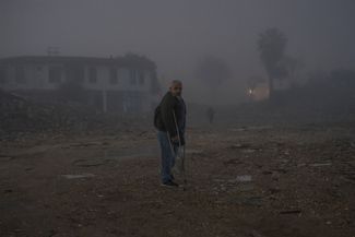 Мужчина на месте снесенного здания в городе Антакья, Турция