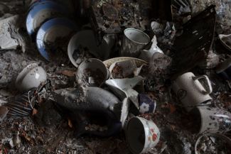 Разбитая посуда на полу уничтоженной обстрелами квартиры в Бородянке. После ухода российских войск из Киевской области украинские спасатели продолжают разбирать завалы