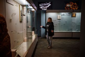 Ольга Гончарова, временный директор Херсонского краеведческого музея, показывает пустые стеклянные витрины в одном из залов учреждения