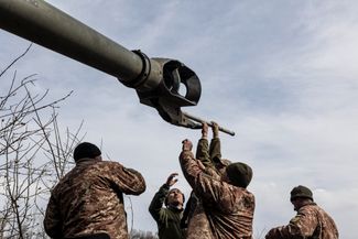 Украинские военные пытаются опустить заклинивший ствол артиллерийского орудия