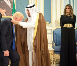 Мелания Трамп наблюдает, как король Саудовской Аравии награждает президента США цепью ордена Короля Абдель-Азиза — государственной наградой за гражданские заслуги. 20 мая 2017 года