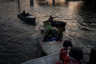 Спасатели перевозят жителей Херсона на лодках по затопленным улицам