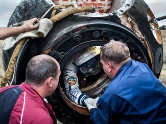 Сотрудники поисково-спасательного отряда помогают астронавту Андреасу Могенсену (Дания) выйти из корабля «СоюзТМА-16М». Казахстан, сентябрь 2015 года.