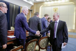 Vladimir Putin shakes hands with Andrey Furskenko