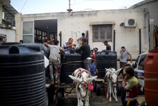 Палестинцы запасаются водой в Хан-Юнисе на юге сектора Газа, 14 октября 2023 года