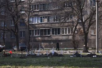 Graves outside of a residential building in Mariupol.