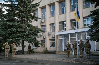 Украинские военнослужащие на церемонии поднятия государственного флага в освобожденном Лимане