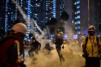 Протестующие разбегаются после того, как полиция применила слезоточивый газ. Гонконг, 5 августа 2019 года