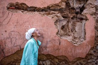 Жительница Марракеша плачет у своего разрушенного дома