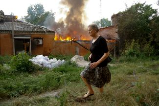 Женщина на окраине Донецка, попавшей под артиллерийский обстрел с украинской стороны
