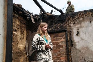 Жительница Донецка у своего разрушенного дома