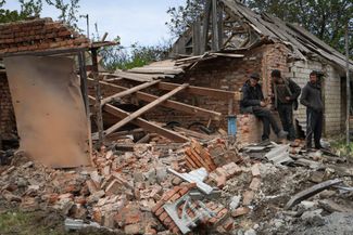 Жители поселка Камышеваха, расположенного примерно в 30 километрах к юго-востоку от Запорожья, разбирают завалы после российского ракетного удара