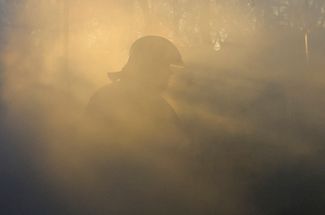 Пожарный в дыму после удара по Донецку
