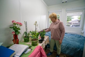 Валентина показывает свои комнатные цветы в комнате модульного городка
