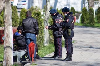 A pair of police officers ask a group of young people to self-isolate in Makhachkala’s Lenin Komsomol Park. April 14, 2020
