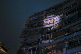 Жители одной из квартир в доме в Днепре, поврежденном российским ракетным ударом, ждут спасателей у себя на балконе