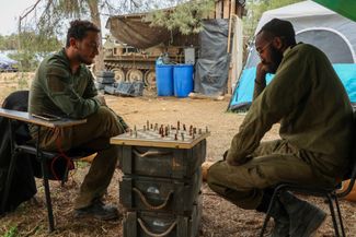 Израильские военнослужащие играют в шахматы во время перемирия на южной границе с сектором Газа, 28 ноября 2023 года