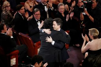 Номинант на «Оскар» за лучший оригинальный сценарий Ноа Баумбак обнимает победившего в этой категории Пон Чжун Хо 