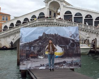 Vladlena, a 25-year-old beautician, stands in front of a photograph of the world’s largest aircraft, Mriya (“dream” in Ukrainian), which was <a href="https://edition.cnn.com/travel/article/antonov-an-225-largest-plane-destroyed-ukraine-scli-intl/index.html" rel="noopener noreferrer" target="_blank">destroyed</a> at the beginning of the full-scale invasion. The photograph, taken by Oleksii Furman, was displayed near the Rialto Bridge in Venice, Italy.