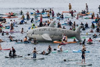 Протестная акция на пляже в Корнуолле. На надувной акуле написано «Ешь людей, а не пластик» 