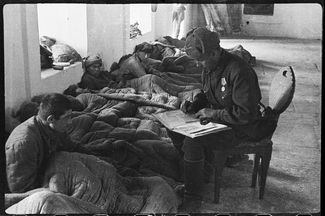 Полевой госпиталь в мечети Ханского дворца в Бахчисарае. Капитан Александр Коротков регистрирует прибывшего раненого под Севастополем рядового Гини Саникидзе, 21 апреля 1944 года