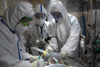 Врачи Осман Османов (справа), Константин Глебов (в центре) и Виталий Мушкин (слева) делают интубацию легких пациенту с коронавирусом. 15 мая 2020 года