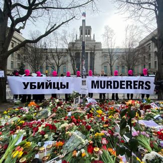Pussy Riot и Любовь Соболь (без балаклавы) перед мемориалом памяти Алексея Навального на бульваре Унтер-ден-Линден. За их спиной посольство России в Берлине. 18 февраля 2024 года