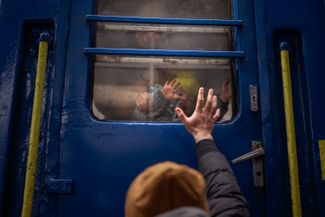Житель Украины прощается со своими женой и сыном, которые едут во Львов. Киев, 3 марта 2022 года