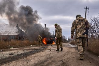 Бойцы 10-й отдельной горно-штурмовой бригады «Эдельвейс» рядом с горящим автобусом после атаки российских беспилотников под Бахмутом. Обстрелянный автобус принадлежал украинским волонтерам