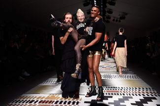 Андреас Кронталер и модель несут Вивьен Вествуд по подиуму на благотворительном показе Fashion For Relief во время Недели моды в Лондоне сезона осень-зима — 2015/16. 19 февраля 2015 года