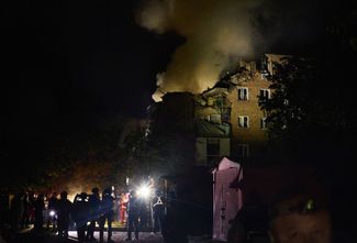 Украинские спасатели у харьковской пятиэтажки, разрушенной российской ракетой