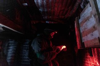 Украинский солдат просматривает свои записи на минометной позиции ВСУ под Кременной