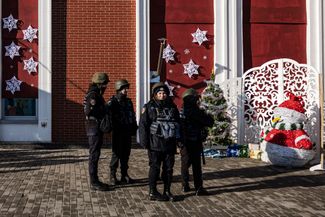 Украинские полицейские следят за порядком во время представления на украшенном ко Дню святого Николая вокзале Краматорска