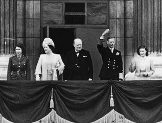 Королевская семья на балконе Букингемского дворца во время празднования Дня Победы в мае 1945 года. Слева направо: принцесса Элизабет, ее мать Елизавета — королева-консорт, премьер-министр Великобритании сэр Уинстон Черчилль, король Георг VI и принцесса Маргарет
