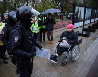 Полицейский с плакатом, изъятым у протестующей