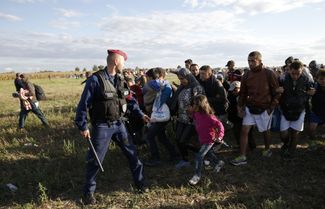 Мигранты покидают венгерскую деревню Режке, 7 сентября 2015 года