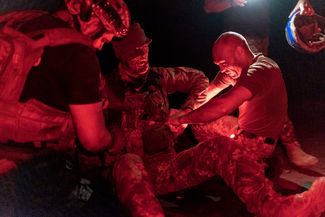 Украинские военные врачи помогают раненому солдату