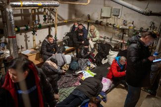 Люди собираются в подвале дома, который выполняет роль бомбоубежища, под вой сирен воздушной тревоги