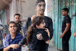 Дети, пострадавшие после обстрела города Рафах на юге сектора Газа, 12 октября 2023 года. По данным ООН, из-за израильских авиаударов более 338 тысяч палестинцев были вынуждены покинуть свои дома.