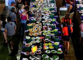 Посетители ярмарки рассматривают овощи, победившие в конкурсах