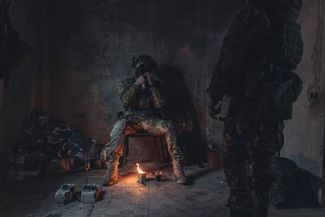 Солдаты ВСУ греются от окопной свечи в заброшенном доме на линии фронта в Донецкой области