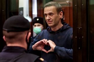 On February 2, a Moscow court replaces Navalny’s probation sentence in the Yves Rocher case with prison time. Pending appellate rulings, Navalny will have to spend at least the next two years and eight months in prison. Pictured above: Navalny gestures to his wife in court.