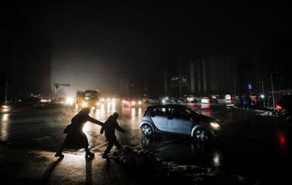 Киевляне переходят дорогу. Из-за отключений электроэнергии в городе выключены фонари и светофоры. Ноябрь 2022 года