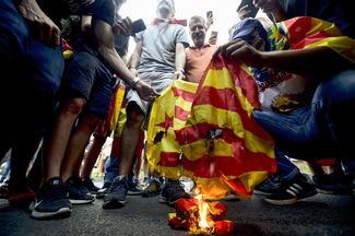 Националисты сжигают флаг Каталонии во время акции в Валенсии, 9 октября 2017 года<br>