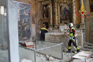 Итальянские пожарные пытаются спасти плащаницу в церкви Святого Франциска в коммуне Аркуата-дель-Тронто, которая была частично разрушена во время землетрясения в августе