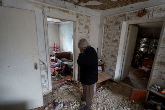 Женщина в доме своей соседки, разрушенном российской армией в селе Благодатное.